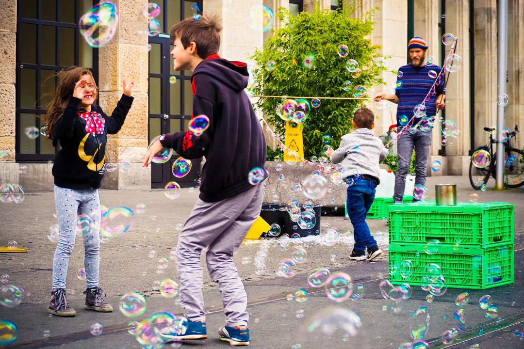Children playing with bubbles in an urban setting